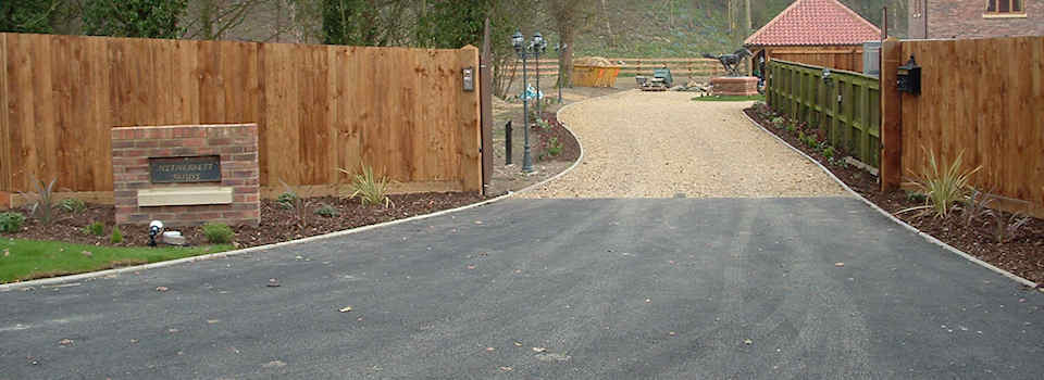 Asphalt and kerbstone edging entrance with shingle drive in Newmarket